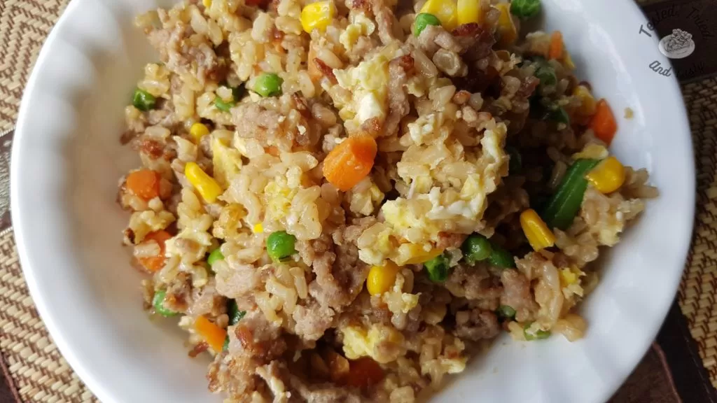 Easy Pork Fried Rice in a white bowl on a bamboo placemat