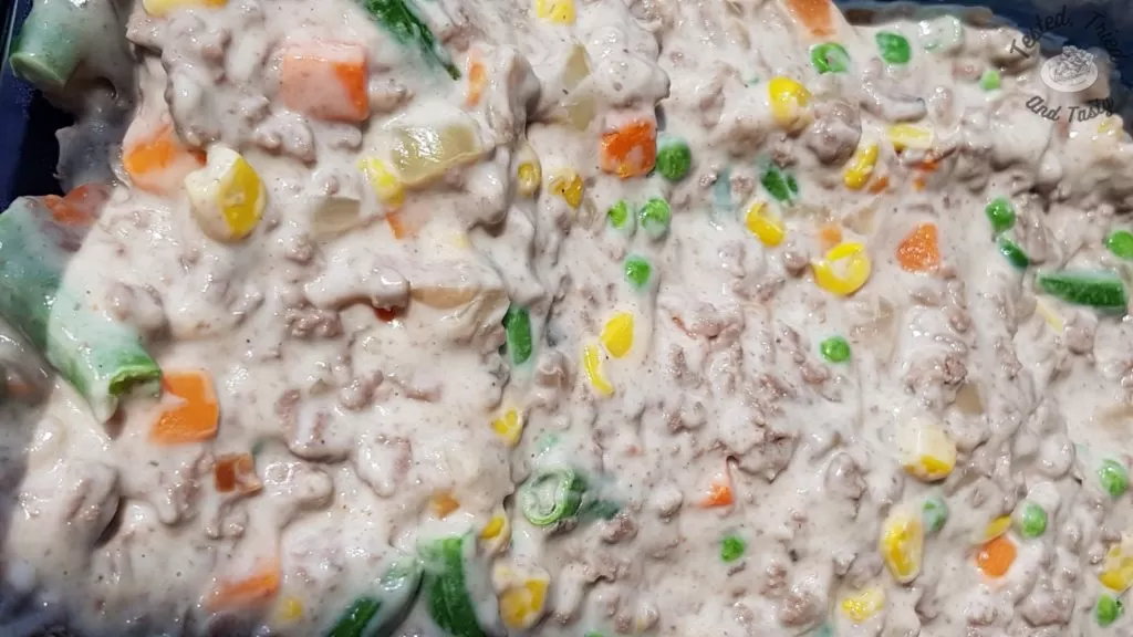 groundbeef, vegetables, sour cream, mushroom soup in casserole dish.