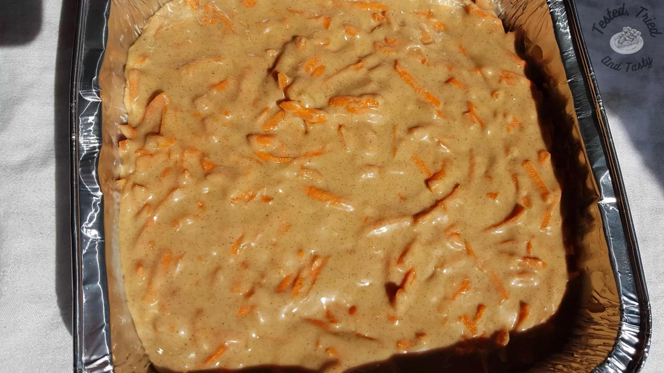 moist and easy carrot cake batter in an aluminum pan