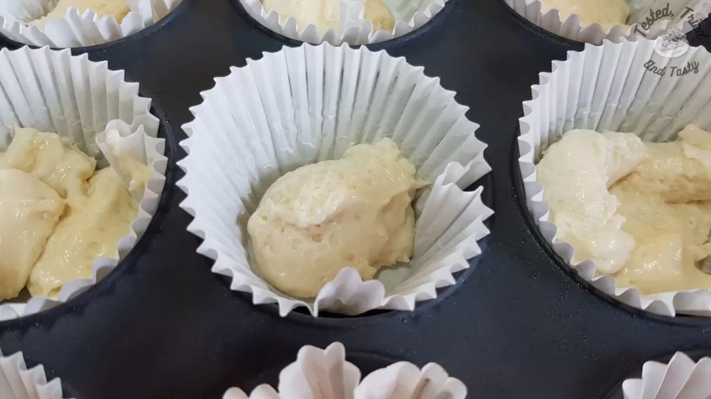 vanilla cupcake batter in cupcake liners in a muffin tin