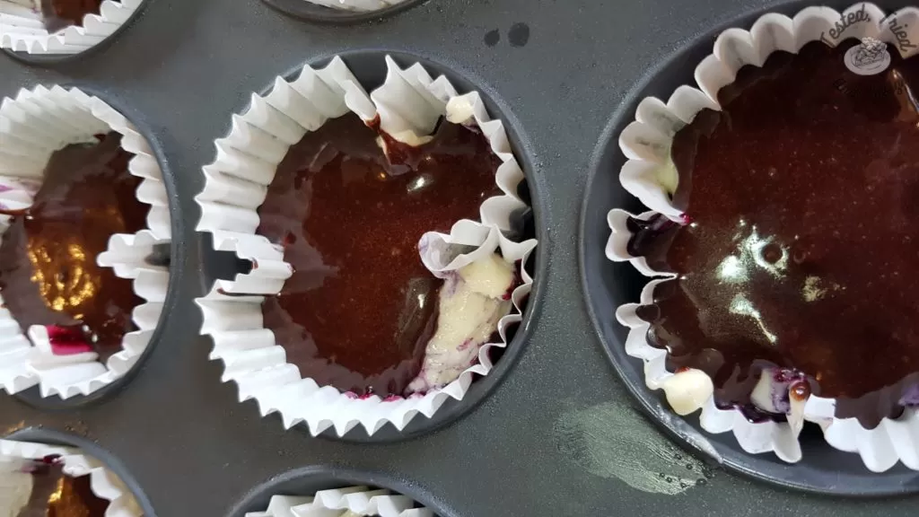 marble cupcakes ready to be baked in a muffin tin