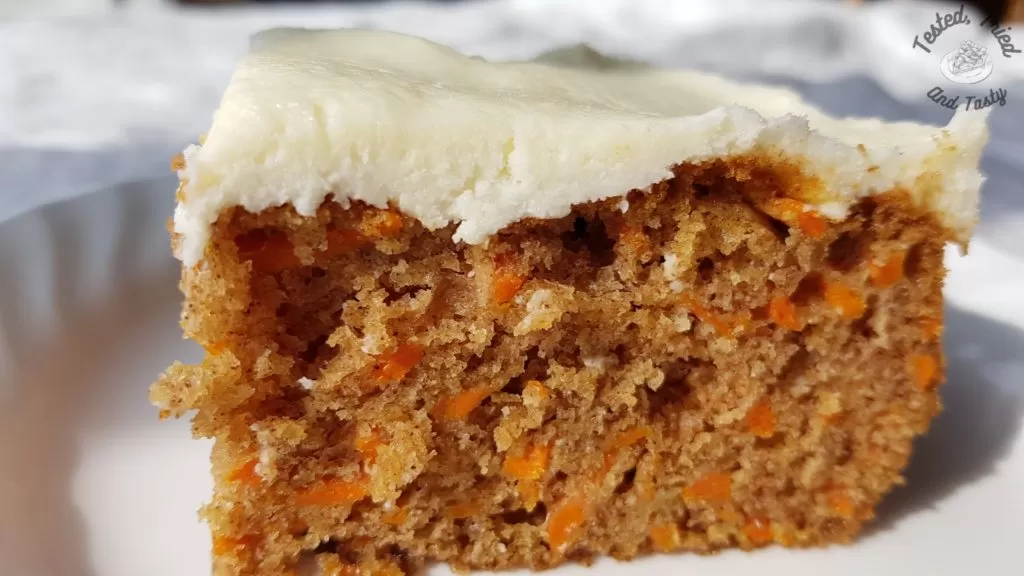 Moist and easy carrot cake on a white plate on a white tablecloth