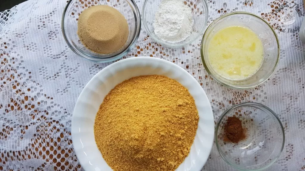 ingredients for the graham wafer crust on a white lace tablecloth.