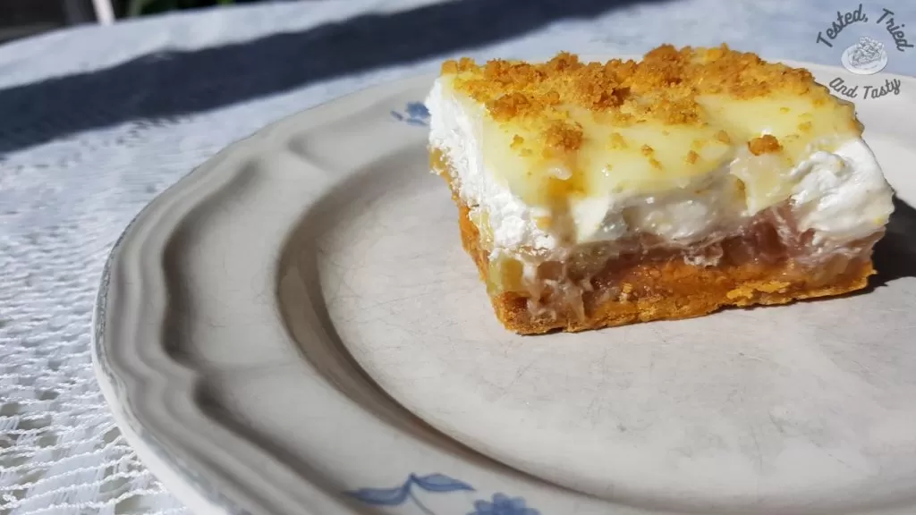 Rhubarb Torte with pudding on a plate on a white lace tablecloth.