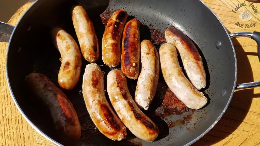 Garlic sausage being cooked in a nonstick saucepan.