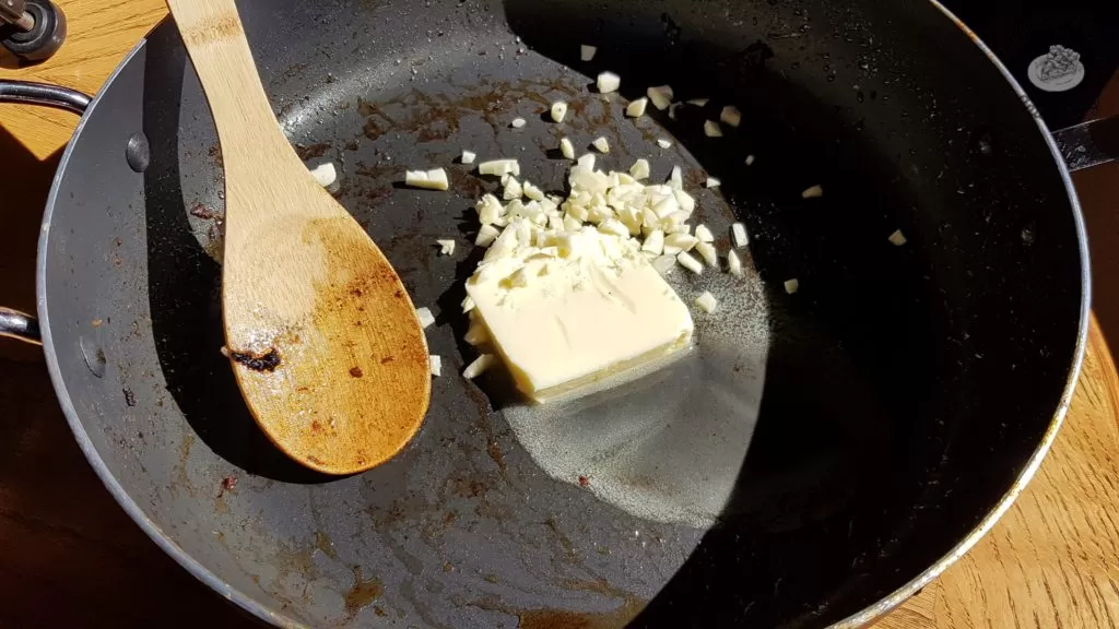 Butter and chopped garlic in a saucepan.