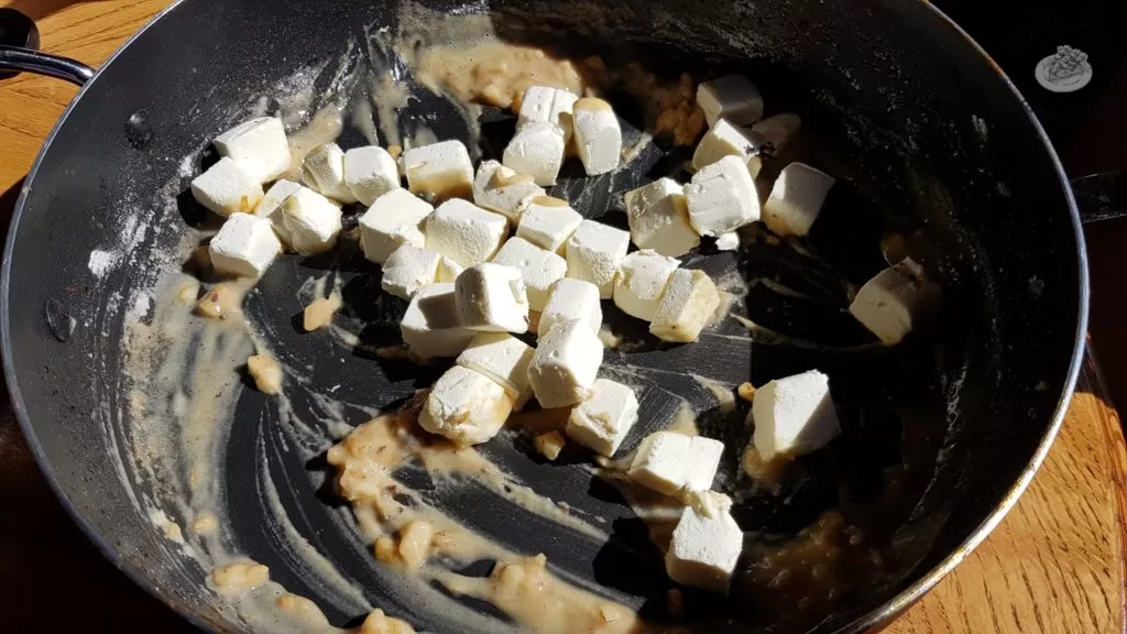 Cream cheese added to butter, garlic and flour in a saucepan.