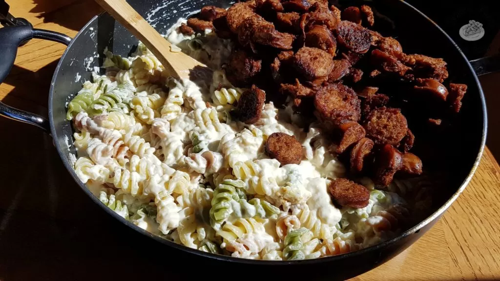 Sliced garlic sausage added to rotini and alfredo sauce for Garlic Sausage and Spinach Alfredo.