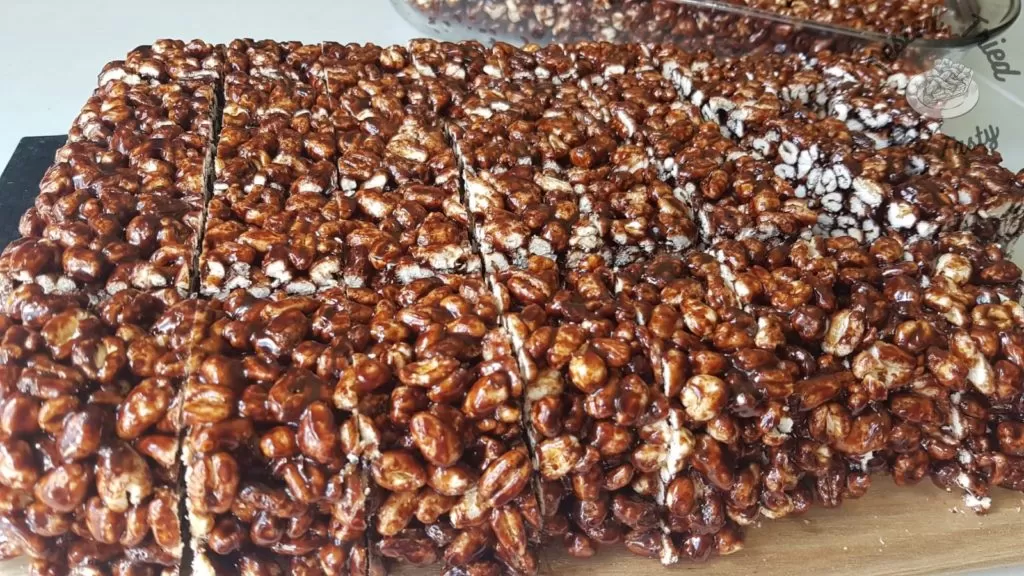 Puffed wheat squares on a wooden cutting board.