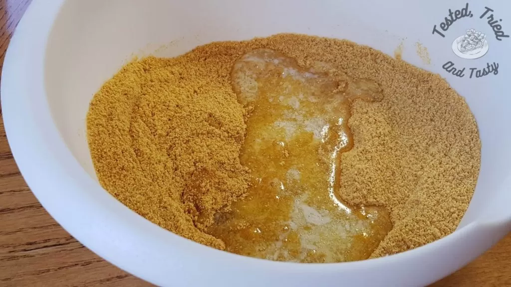 graham wafers and melted butter in a white bowl.