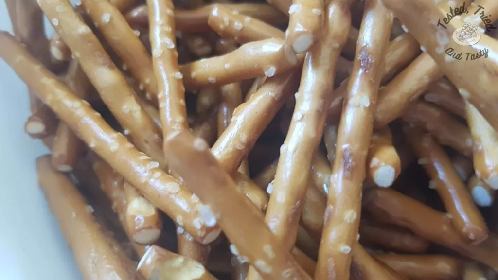 Pretzel sticks in a white bowl.