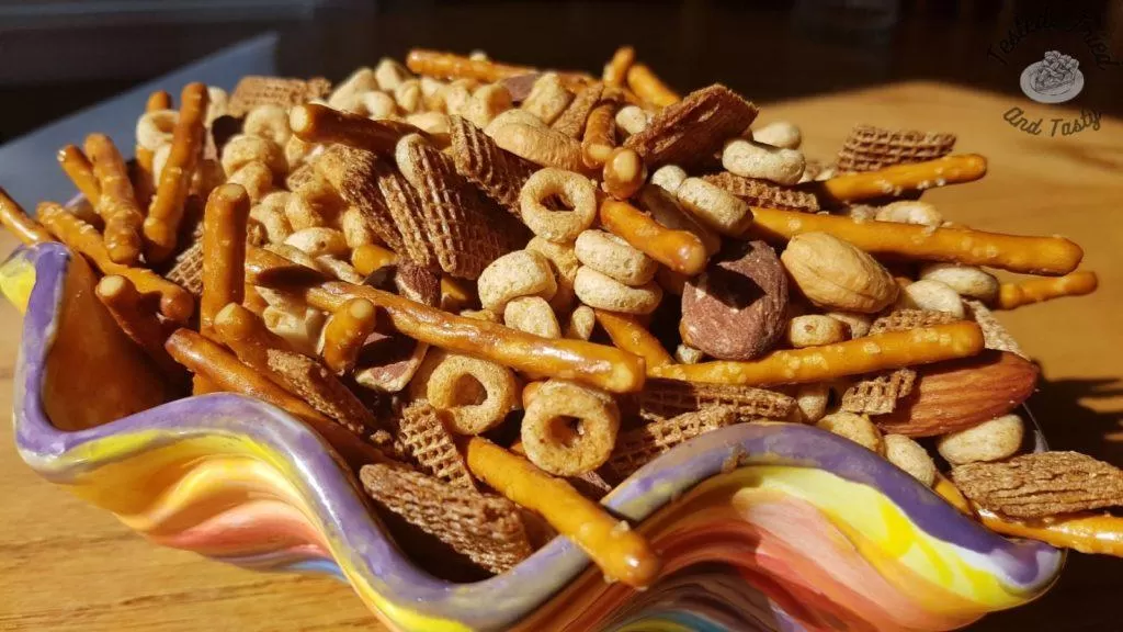 Homemade Nuts and Bolts recipe in a colorful ceramic bowl.