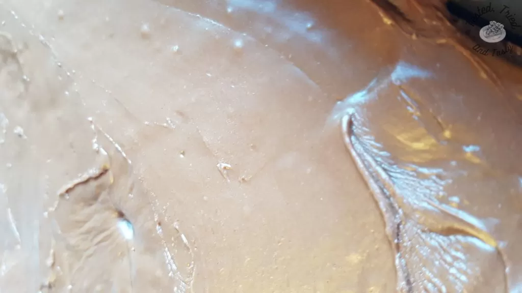 Icing poured onto brownies for Fudgy Texas Brownies.