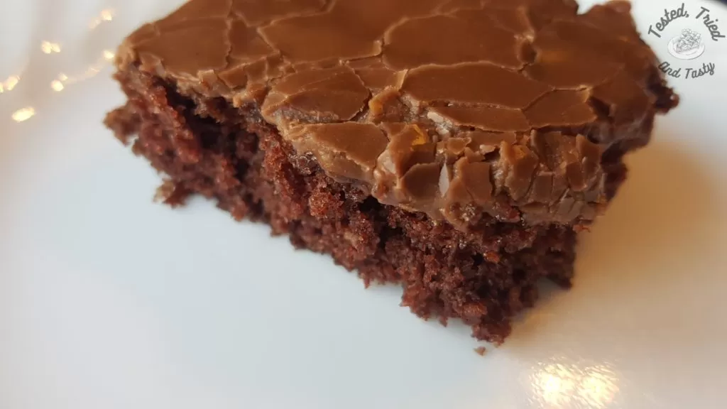 Close up of a fudgy texas brownie on a white plate.