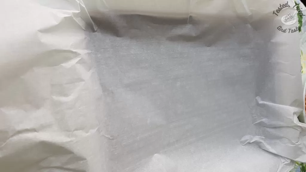 Llining the pan with parchment paper.