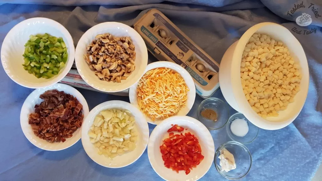 Ingredients for breakfast hashbrown casserole on a blue tablecloth.