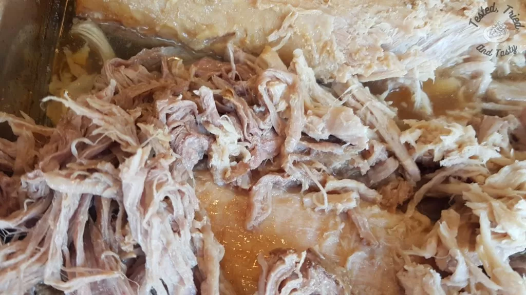 Shredding pork for pulled pork recipe.