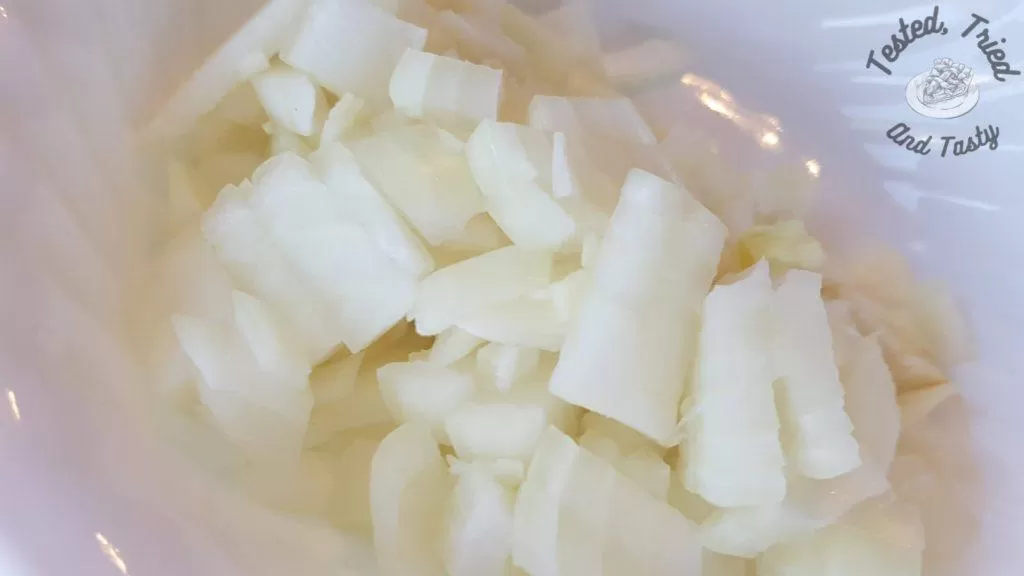 Chopped onions in a white bowl.