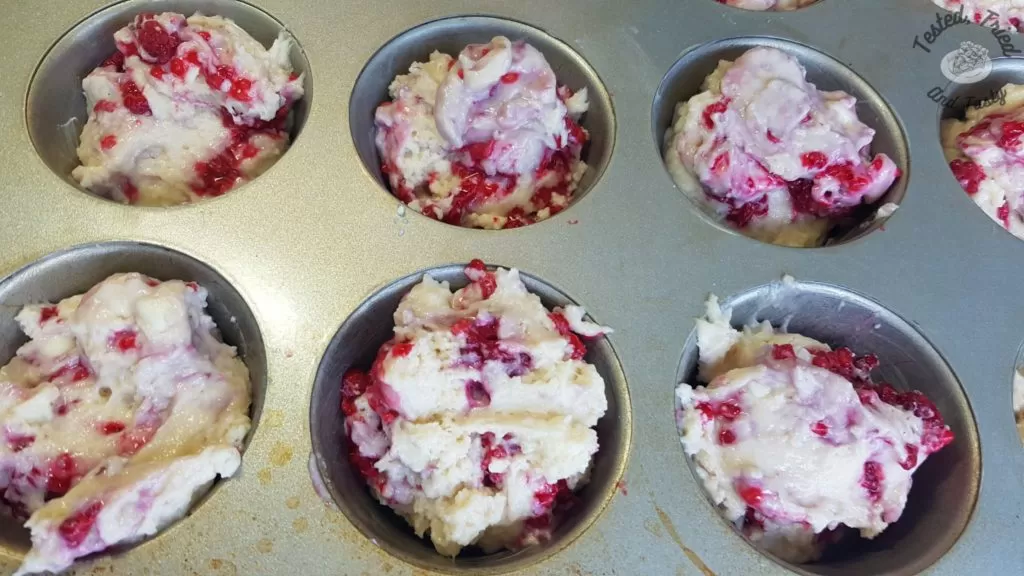 Raspberry White Chocolate Muffins in a muffin tin ready to be baked.