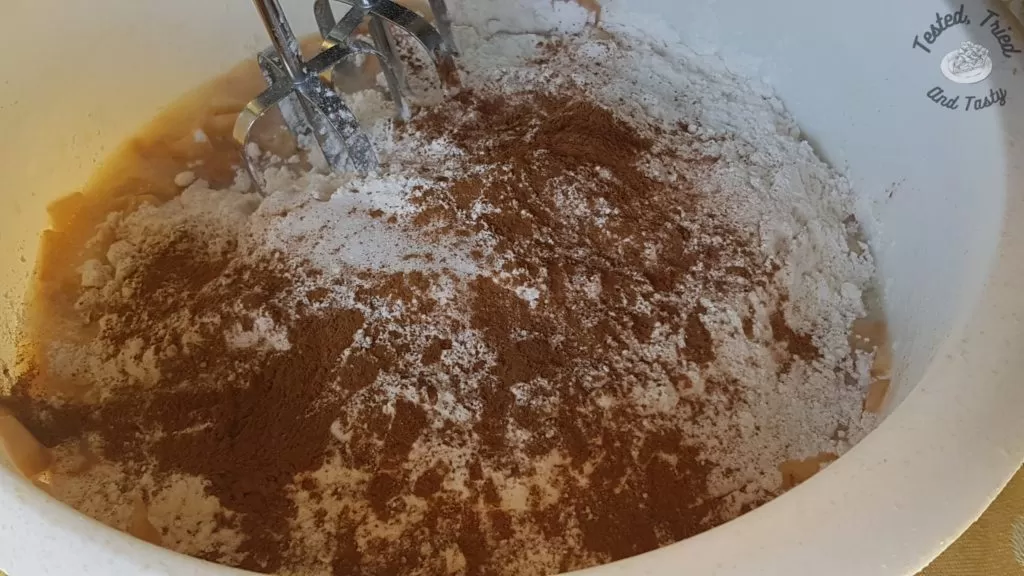 Dry ingredients added to the liquid ingredients for apple streusel muffins.