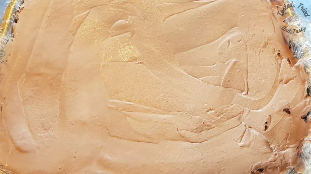 Chocolate ice cream put on top of the hot fudge sauce for ice cream cake.