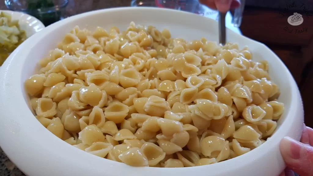 Small pasta shells with pickle juice soaking into them.