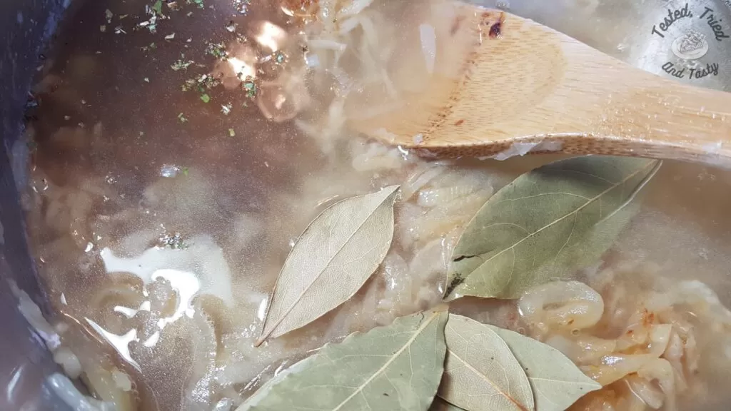 Beef broth and bay leaves with the onions for french onion soup.