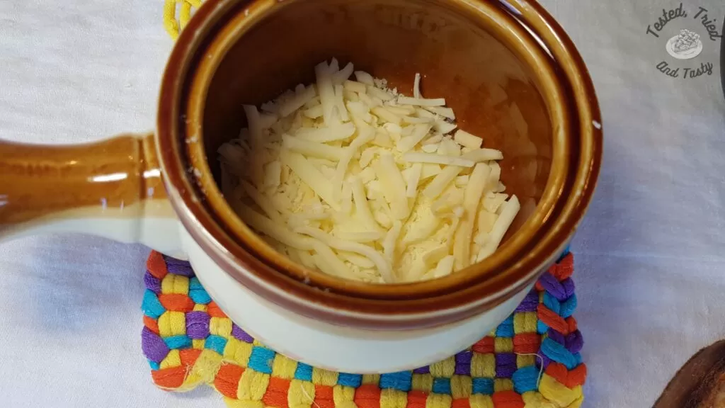 Cheese in the bottom of a ceramic crock.