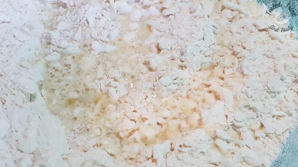 Adding liquid ingredients to the dry ingredients for pie dough.