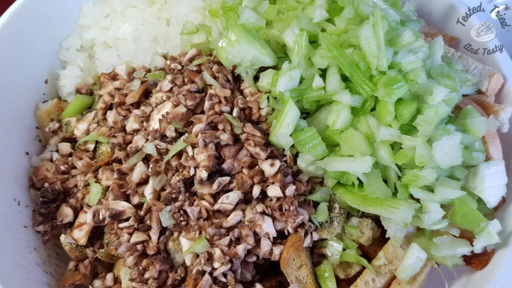 Mushrooms, onions, and celery added to seasoned dry bread cubes,