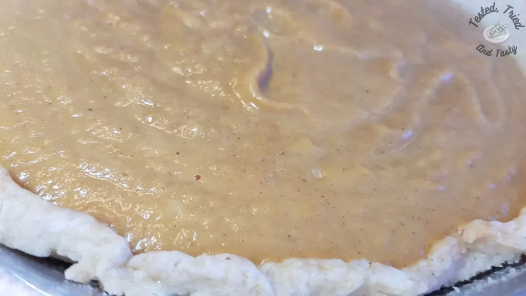 Pumpkin filling poured into prepared pie crust.