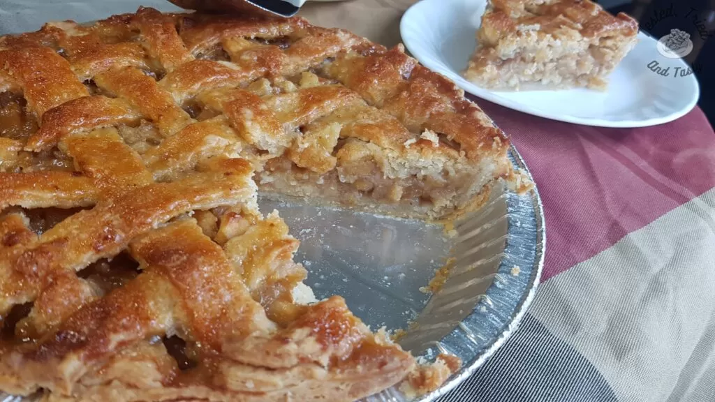 Caramel apple pie with a slice cut out.