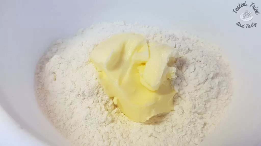 Cake mix and butter in a white bowl.
