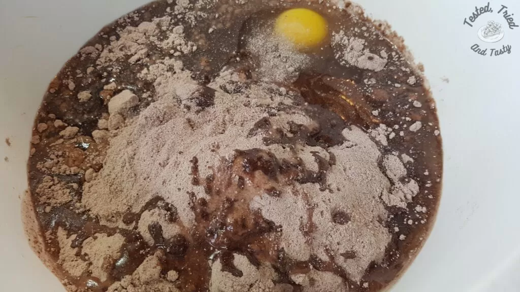Cake mix, egg, oil, and water in a white bowl.