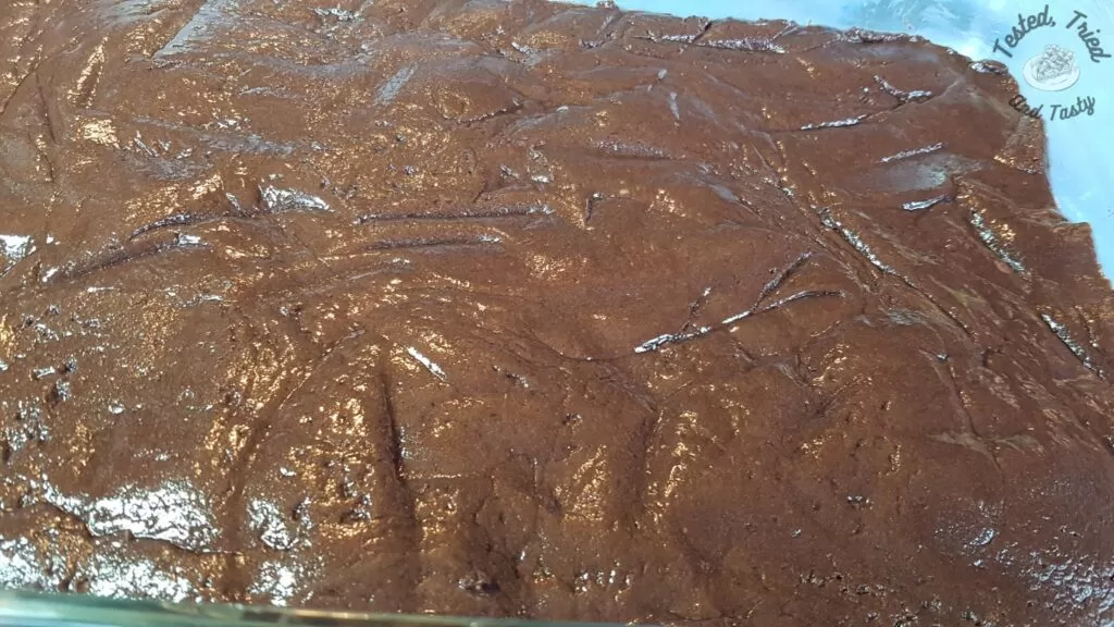 Brownie crust layer in a greased 9x13 inch pan.
