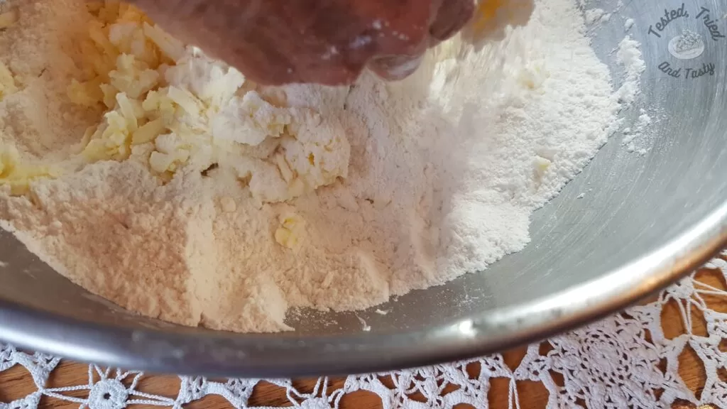 Mixing the frozen grated butter into the dry ingredients.