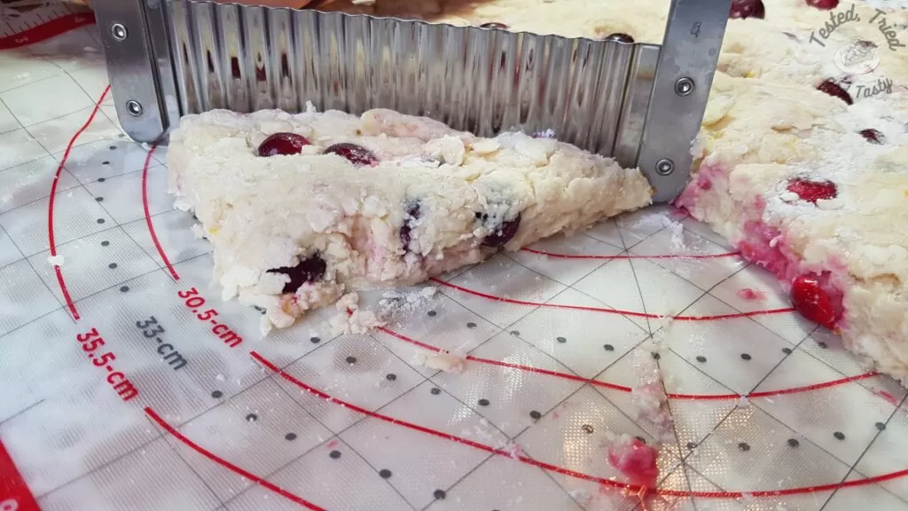 Cutting cranberry orange scones with a cutter.