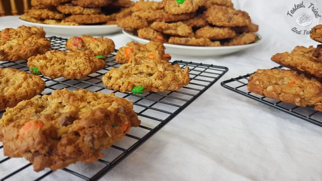 Monster cookies on a wire cooling rack.