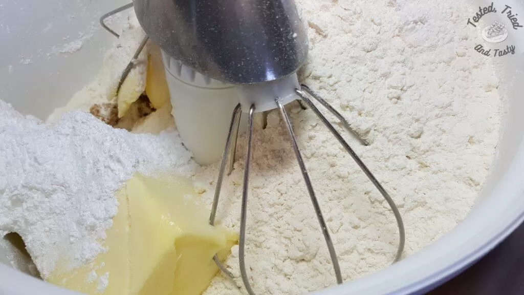 Flour added to the butter and both sugars in a mixer.