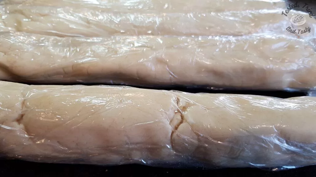 Shortbread cookie dough rolled and wrapped in plastic wrap.