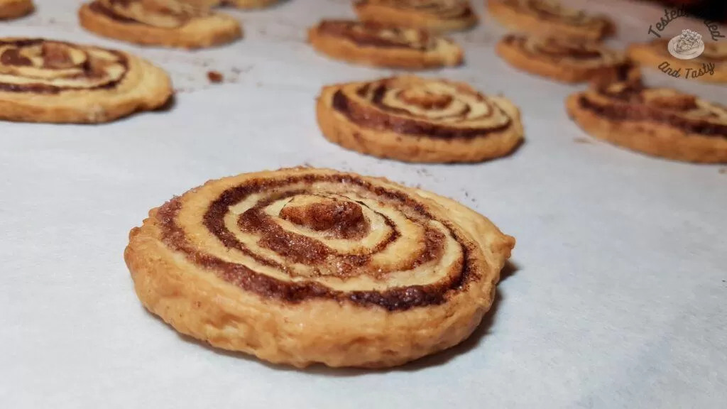 Cinnamon roll cookies on parchmet lined baking sheet.