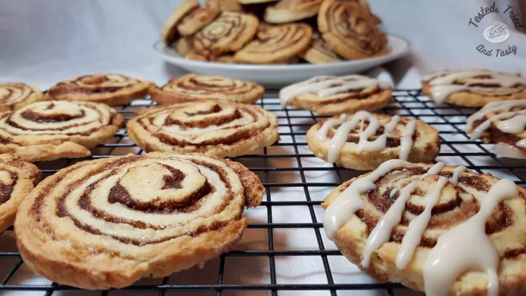 Cinnamon roll cookies on a wire cooling rack.