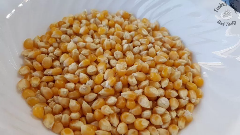 Popcorn kernels in a white bowl.