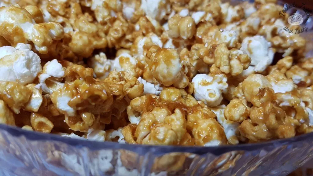 Caramel popcorn in a clear bowl.