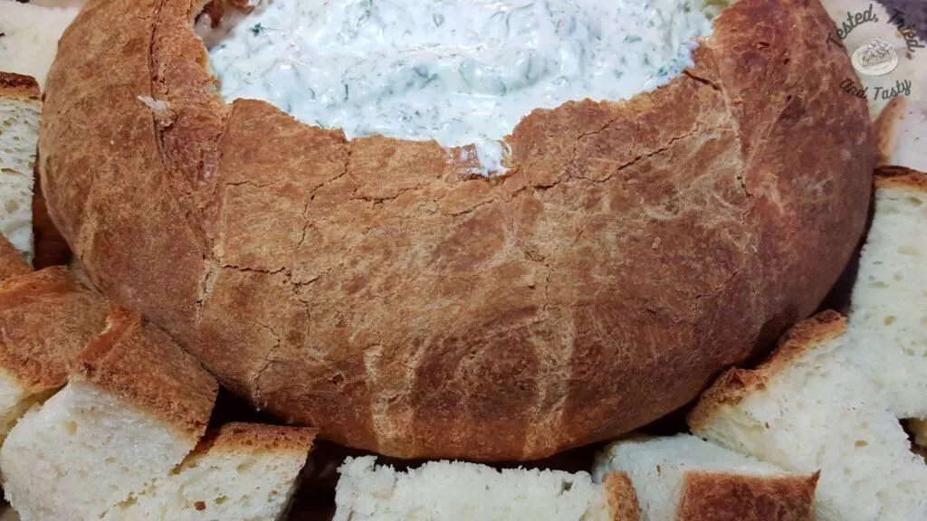 Spinach dip in a sourdough bread loaf.