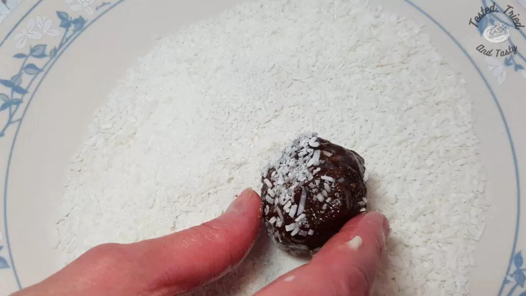 Rolling the snowball cookie in coconut.