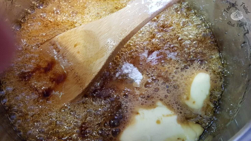 Boiling peanut brittle caramel ingredients.