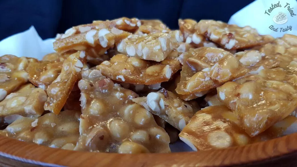 Peanut brittle in a wooden bowl.