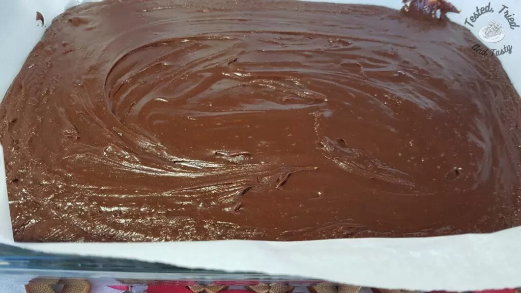 Finished chocolate fudge in a dish with parchment paper.