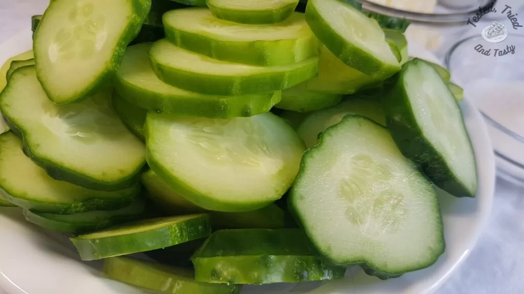 Sliced english cucumbers in a white bowl.